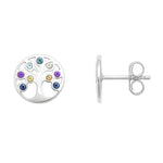 Ein Paar silberner Ohrstecker in runder Form mit Lebensbaum-Design. Die Äste des Baums sind mit farbigen Zirkonia-Steinen in Blau, Grün, Gelb, Rosa und Violett besetzt. Einer der Ohrstecker ist von vorne zu sehen, der andere in der Seitenansicht mit sichtbarem Steckverschluss. Beide liegen auf weißem Hintergrund, professionell ausgeleuchtet.