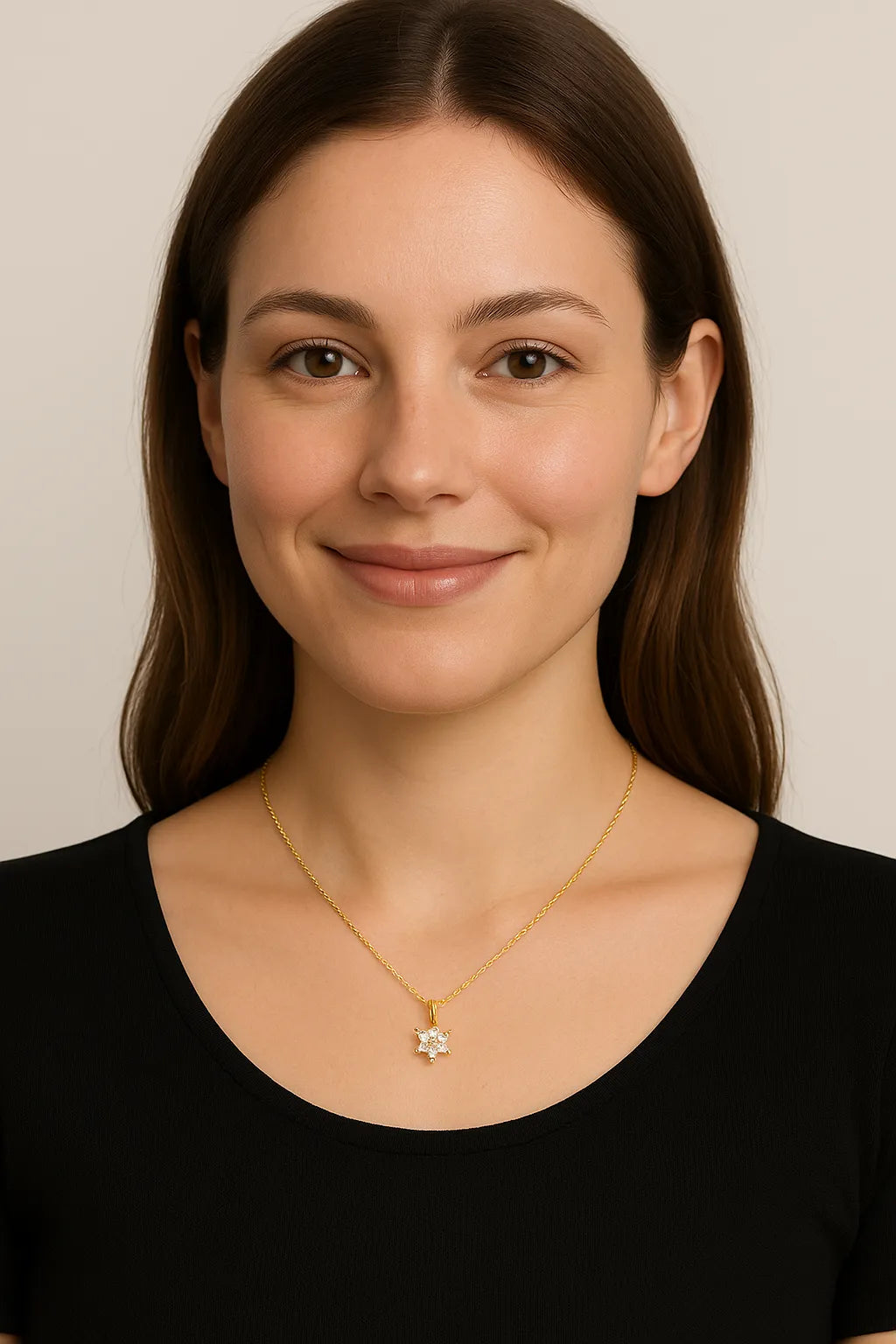 Nahaufnahme einer lächelnden jungen Frau mit langen braunen Haaren und einer zierlichen goldenen Halskette mit sternförmigem Anhänger