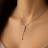 Silberne Y-Halskette mit kleinen Zirkonia, getragen am Hals einer Frau. Der filigrane Anhänger mit vier runden Steinen fällt elegant ins Dekolleté und wirkt feminin und edel.