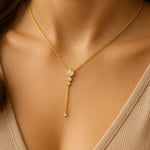 Vergoldete Y-Halskette mit funkelnden Zirkonia-Steinen am Hals einer Frau, eleganter Anhänger mit vier runden Fassungen, femininer Halsschmuck für Alltag und Anlass.