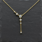 Elegante, goldplattierte Silberkette mit filigranem Kettenverlauf und funkelnden, runden Zirkonia-Steinen. Das Schmuckstück ist als Y-Kette designt, bei der die Steine kaskadenförmig am Hals und an einem langen, zarten Anhänger herabhängen.