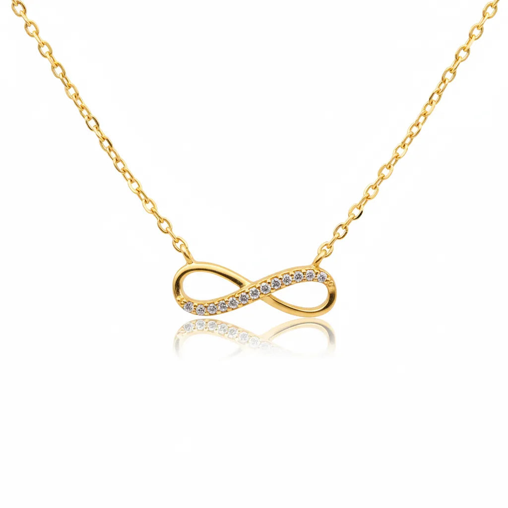 Vergoldete Damen Halskette mit filigranem Infinity-Anhänger, teilweise mit klaren Zirkonia-Steinen besetzt, Symbol für ewige Liebe, freigestellt auf weißem Hintergrund.
