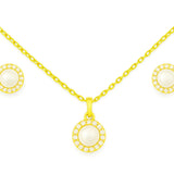 Vergoldetes Schmuckset mit Halskette und Ohrsteckern, jeweils mit runder, weißer Perle in goldener Fassung und funkelnden Zirkonia-Steinen auf weißem Hintergrund.