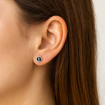 Nahaufnahme eines Ohrs mit einem eleganten Ohrstecker aus 925er Silber und rundem Labradorit-Cabochon, der in schimmernden Blau- und Grüntönen leuchtet.