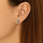 Nahaufnahme eines Ohres mit einem eleganten Ohrstecker in Marquiseform aus 925er Sterlingsilber, gefasst mit einem schimmernden Labradorit-Cabochon, der in Blau- und Grautönen irisierend leuchtet. Der Ohrstecker wirkt dezent und edel am Ohr getragen.