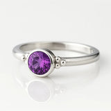 Eleganter Silberring mit 4 mm rund facettiertem Amethyst in Zargenfassung und dekorativen Silberkügelchen, Sterling Silber 925, Produktfoto Schmuck.