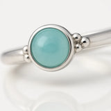 Zarter Damenring aus 925 Sterling Silber mit rundem Aqua-Chalcedon Cabochon in glatter Zargenfassung und feinen Silberkugeln an der Ringschiene – eleganter türkisfarbener Edelsteinring für Damen, minimalistischer Silberring als Geschenk oder Verlobungsring.