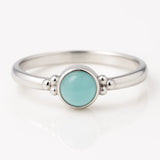 "Zarter Damenring aus Silber mit rundem Aqua-Chalcedon Cabochon in Zargenfassung und Kugeldetails am Ringband – eleganter Silberring mit pastell-türkisfarbenem Edelstein"