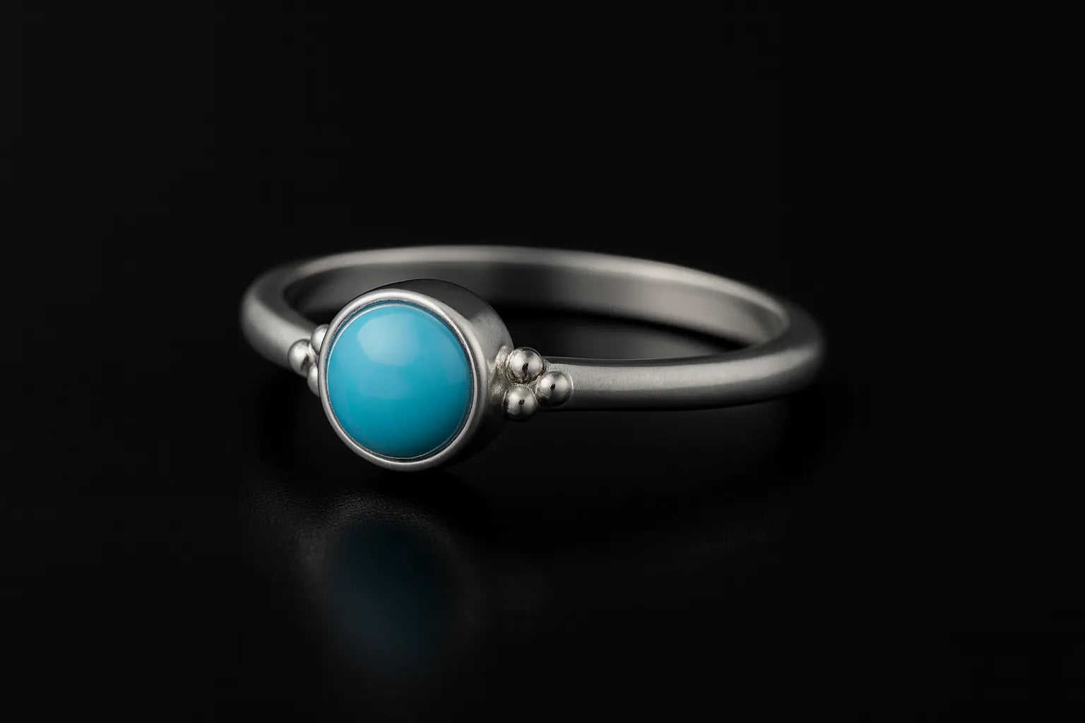 Damenring aus Sterling Silber mit rundem blauem Chalcedon Cabochon (4 mm) in Zargenfassung – filigraner Silberring mit hellblauem Edelstein, edel inszeniert auf schwarzem Hintergrund mit Spiegelung.