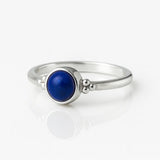 Eleganter Damenring aus Sterling Silber mit rundem Lapislazuli Cabochon in Zargenfassung – filigraner Silberring mit tiefblauem Edelstein auf weißem Hintergrund.