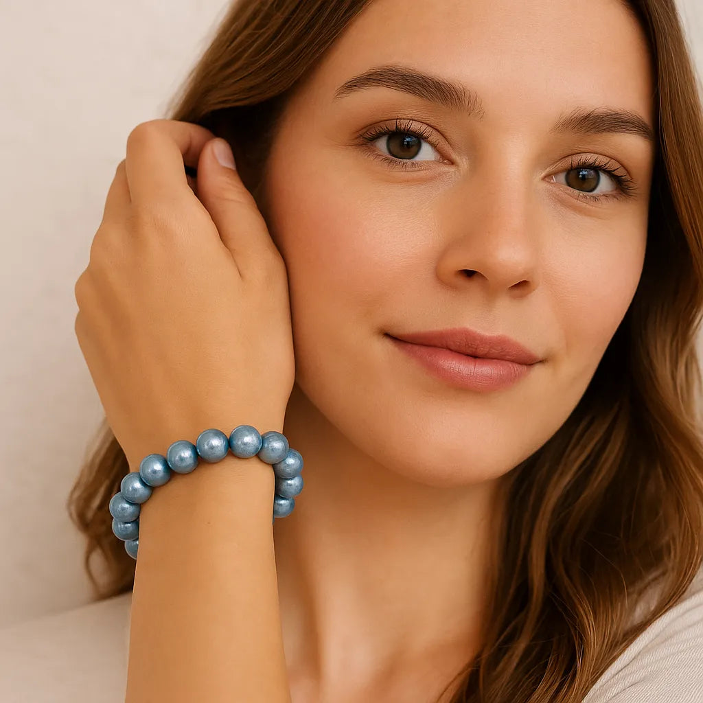 Junge Frau mit offenem Haar trägt ein hellblaues Perlenarmband am Handgelenk.