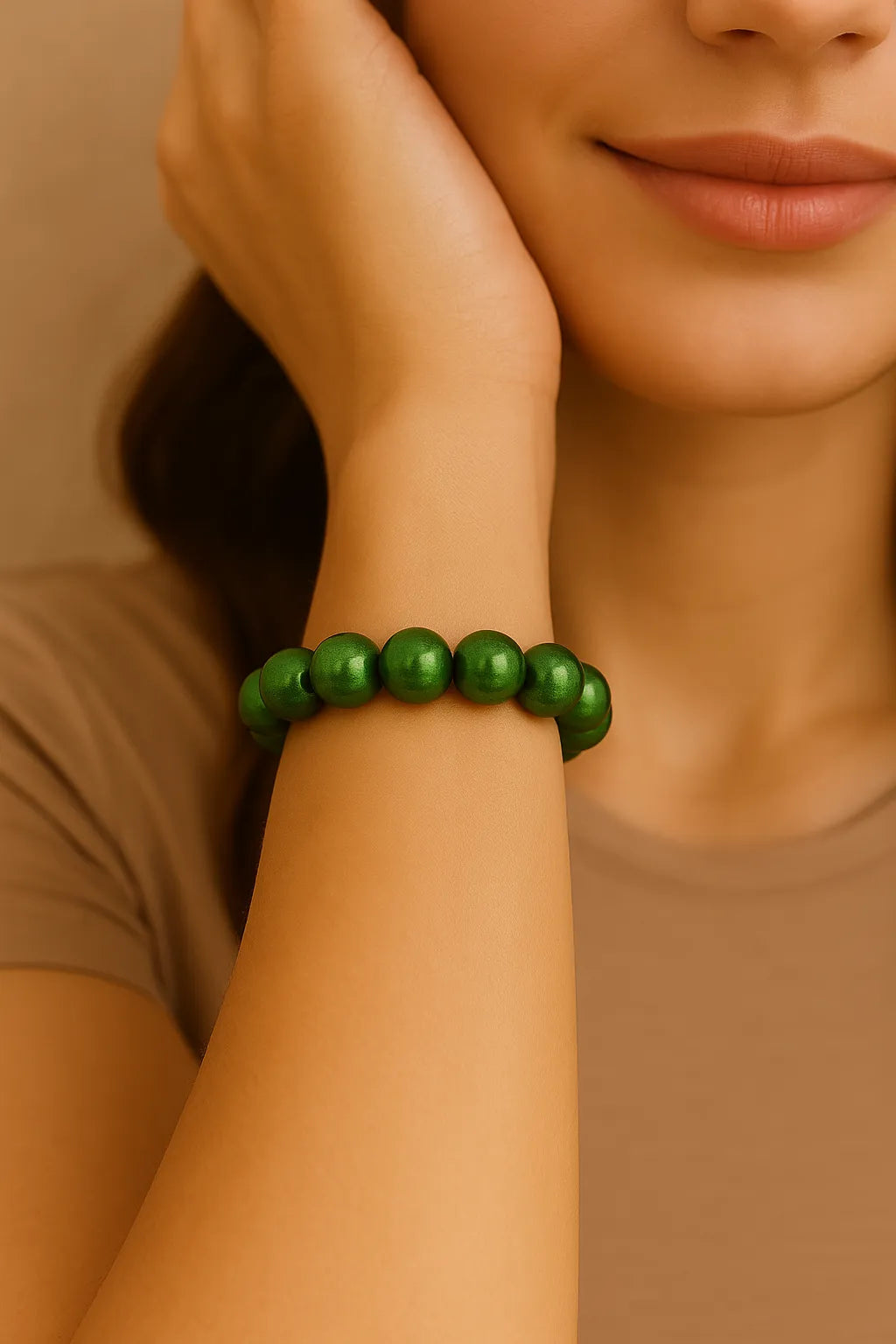 Nahaufnahme einer Frau, die ein elastisches 3D Wonderperlen Armband mit glänzenden, smaragdgrünen Perlen am Handgelenk trägt.