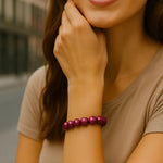 Junge Frau in urbaner Umgebung trägt ein glänzendes pink-violettes 3D Wonderperlen Armband am rechten Handgelenk, Fokus liegt auf dem Schmuckstück.