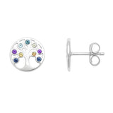 Ein Paar silberner Ohrstecker in runder Form mit Lebensbaum-Design. Die Äste des Baums sind mit farbigen Zirkonia-Steinen in Blau, Grün, Gelb, Rosa und Violett besetzt. Einer der Ohrstecker ist von vorne zu sehen, der andere in der Seitenansicht mit sichtbarem Steckverschluss. Beide liegen auf weißem Hintergrund, professionell ausgeleuchtet.
