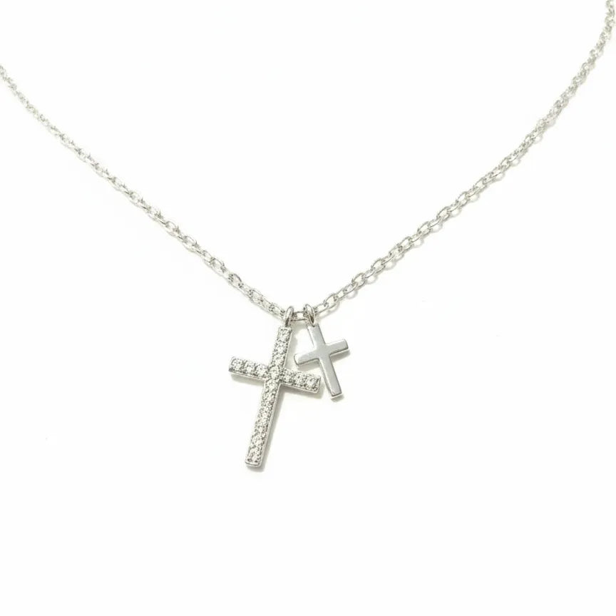 Silberne Halskette mit zwei Kreuzanhängern, großer Kreuzanhänger mit funkelnden Zirkonia, kleiner glatt poliert, vor weißem Hintergrund – Damen Schmuck 925 Sterling Silber.