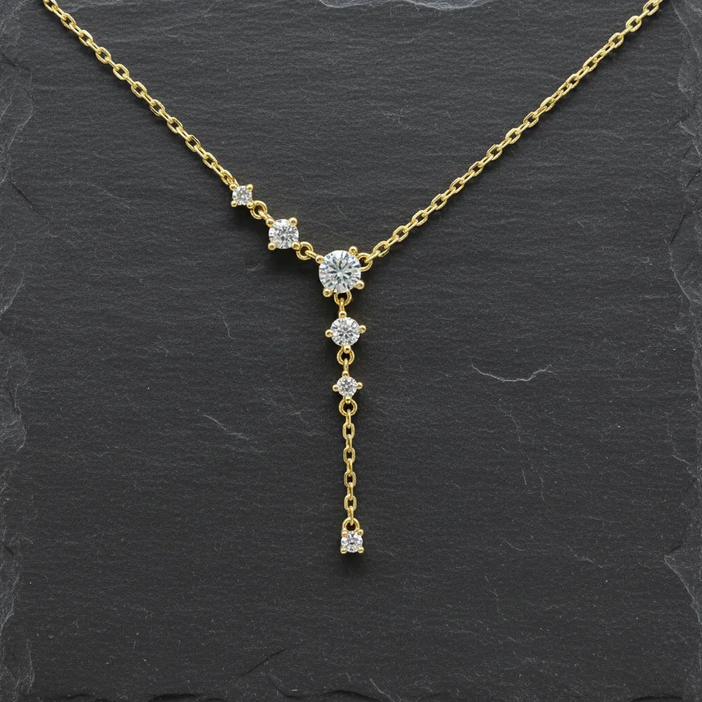 Elegante, goldplattierte Silberkette mit filigranem Kettenverlauf und funkelnden, runden Zirkonia-Steinen. Das Schmuckstück ist als Y-Kette designt, bei der die Steine kaskadenförmig am Hals und an einem langen, zarten Anhänger herabhängen.