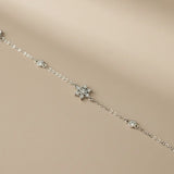 Silberne Armkette liegend mit funkelndem Schneeflocken-Design