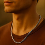 Herren Edelstahl-Kordelkette (Rope Chain), getragen am Hals eines Mannes bei Golden-Hour-Licht; Nahaufnahme mit warmen Hauttönen, moderner Casual-Look.
