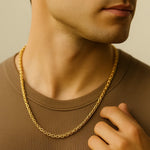 Herren Königskette goldfarben 4 mm, aus Edelstahl, getragen am Hals eines Mannes; Nahaufnahme im warmen Fensterlicht, moderner Premium-Look.
