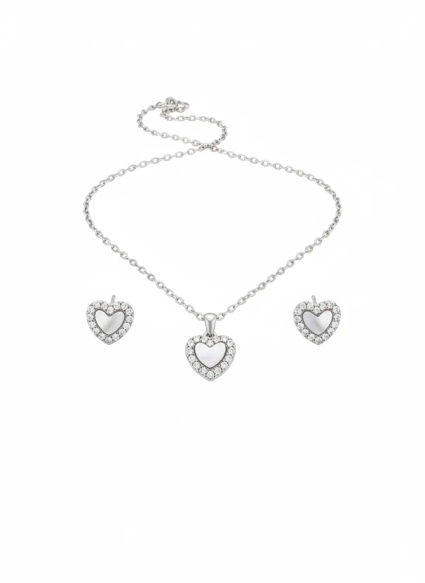 Silbernes Damen Schmuckset mit Herzanhänger: feine Halskette und passende Herz Ohrstecker mit schimmerndem Zentrum und Zirkonia-Rand auf weißem Hintergrund.