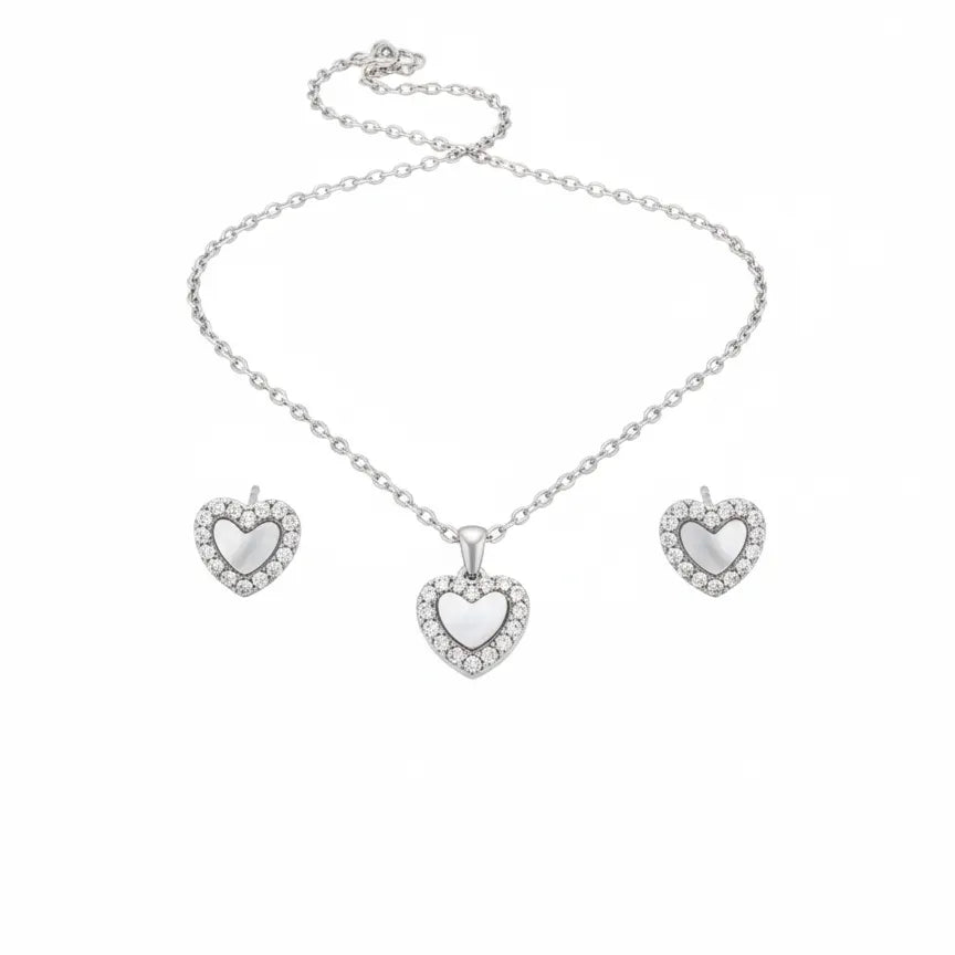 Silbernes Damen Schmuckset mit Herzanhänger: feine Halskette und passende Herz Ohrstecker mit schimmerndem Zentrum und Zirkonia-Rand auf weißem Hintergrund.