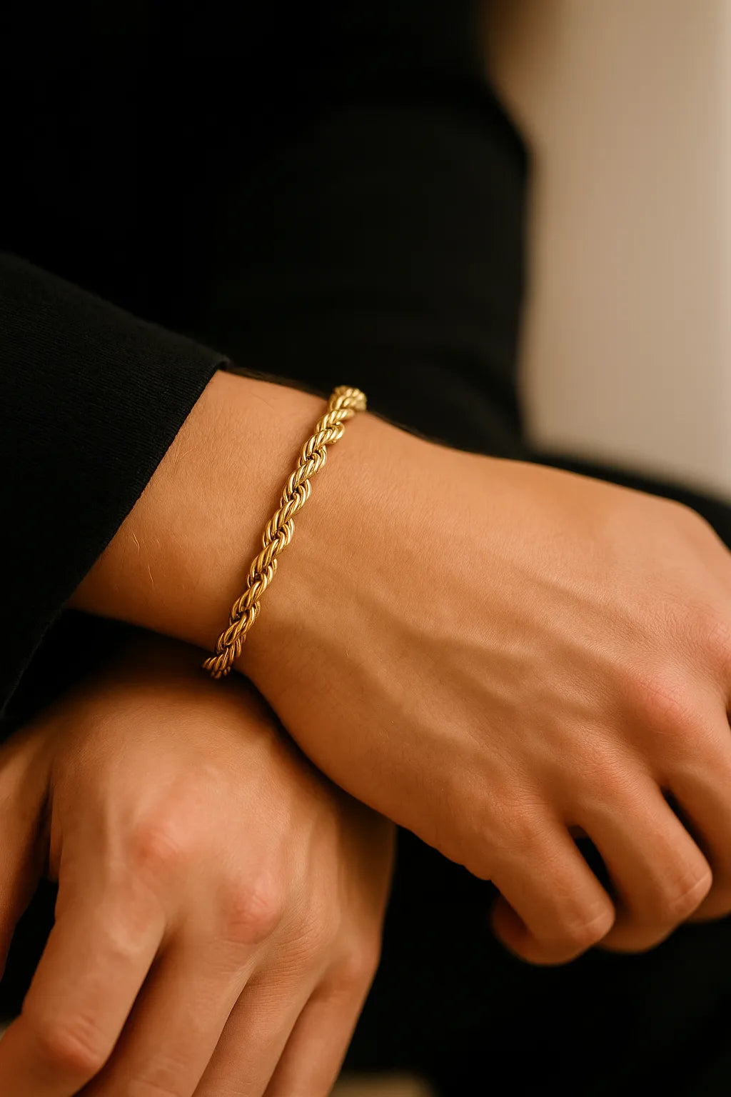 Herren-Armband vergoldeter Edelstahl, Rope-Chain/Seilkette am Handgelenk; Nahaufnahme im sanften Fensterlicht, polierte Twisted-Glieder, moderner Premium-Look.
