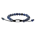 Verstellbares Herren Armband aus facettierten blauen Sodalit-Perlen mit schwarzem Zugband und poliertem Edelstahl-Zwischenteil auf weißem Hintergrund.