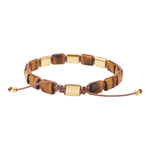 Das Bild zeigt ein verstellbares Herrenarmband aus rechteckigen Tigerauge-Steinen mit goldfarbenen Edelstahlelementen und braunem Makramee-Band für modebewusste Männer.