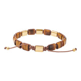 Das Bild zeigt ein verstellbares Herrenarmband aus rechteckigen Tigerauge-Steinen mit goldfarbenen Edelstahlelementen und braunem Makramee-Band für modebewusste Männer.