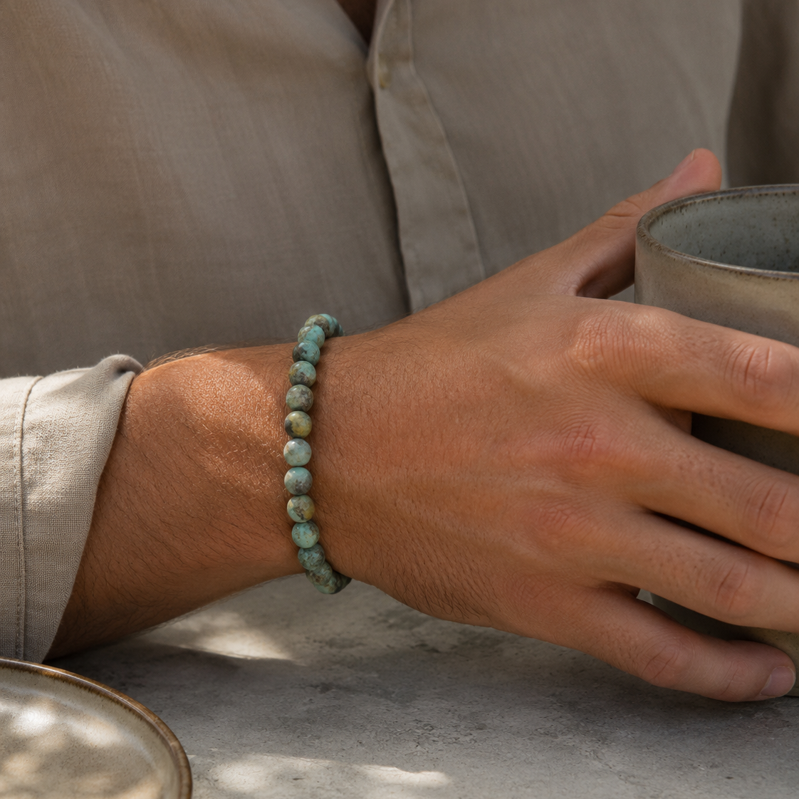 SON Herrenarmband aus 6 mm African-Turquoise-Perlen, alltagstauglich getragen beim Halten einer Keramiktasse