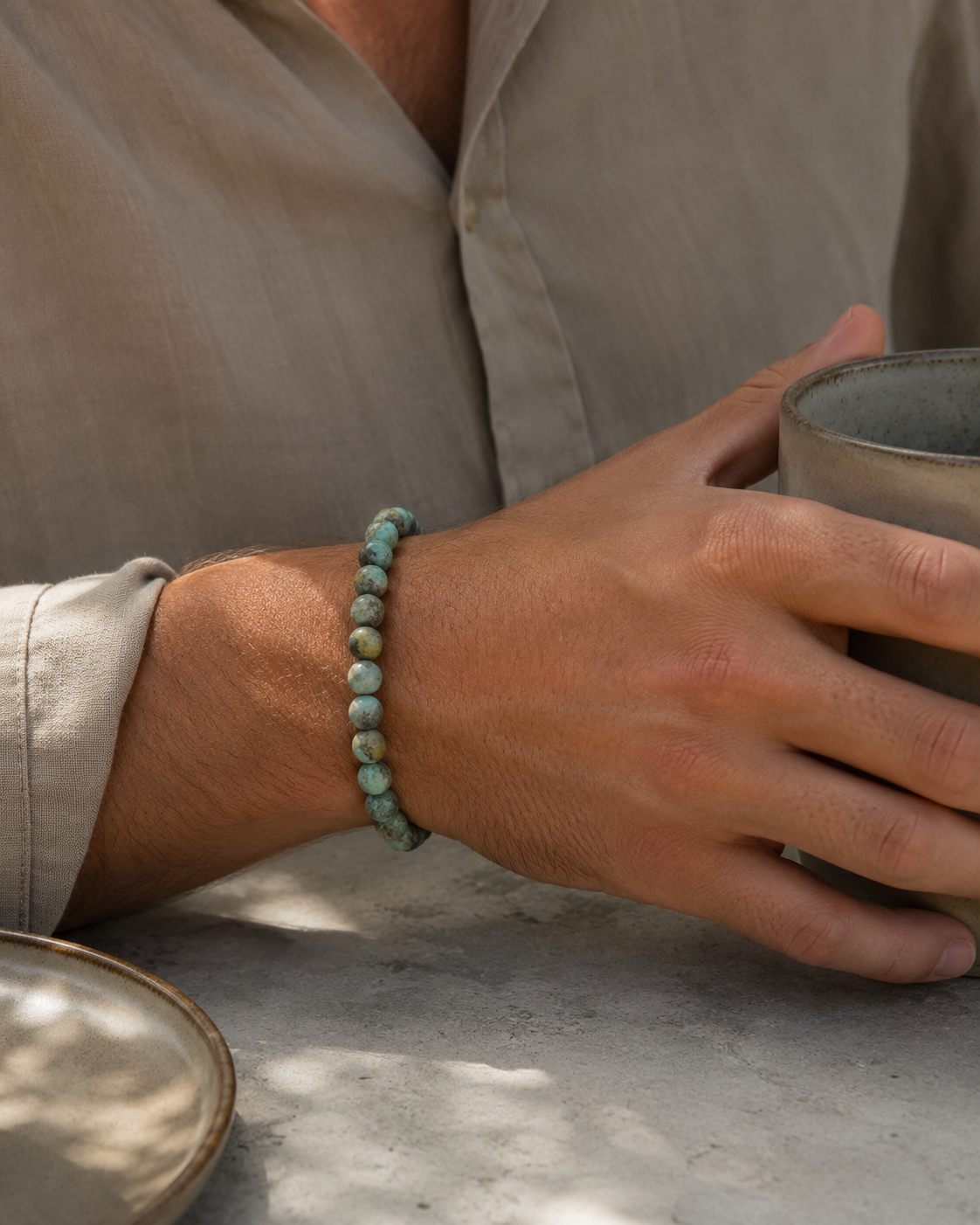 SON Herrenarmband aus 6 mm African-Turquoise-Perlen, alltagstauglich getragen beim Halten einer Keramiktasse