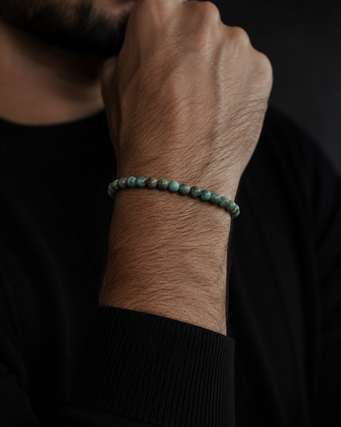 SON Herrenarmband aus 6 mm African-Turquoise-Perlen, markant getragen zu schwarzem Strick im maskulinen Premium-Look