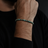 SON Herrenarmband aus 6 mm African-Turquoise-Perlen, markant getragen zu schwarzem Strick im maskulinen Premium-Look