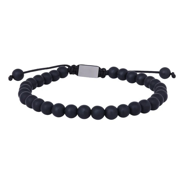 Das Bild zeigt ein verstellbares Herrenarmband aus runden schwarzen Onyx-Perlen mit Edelstahl-Element und Makramee-Band, das Männern einen sportlich-eleganten Look verleiht.