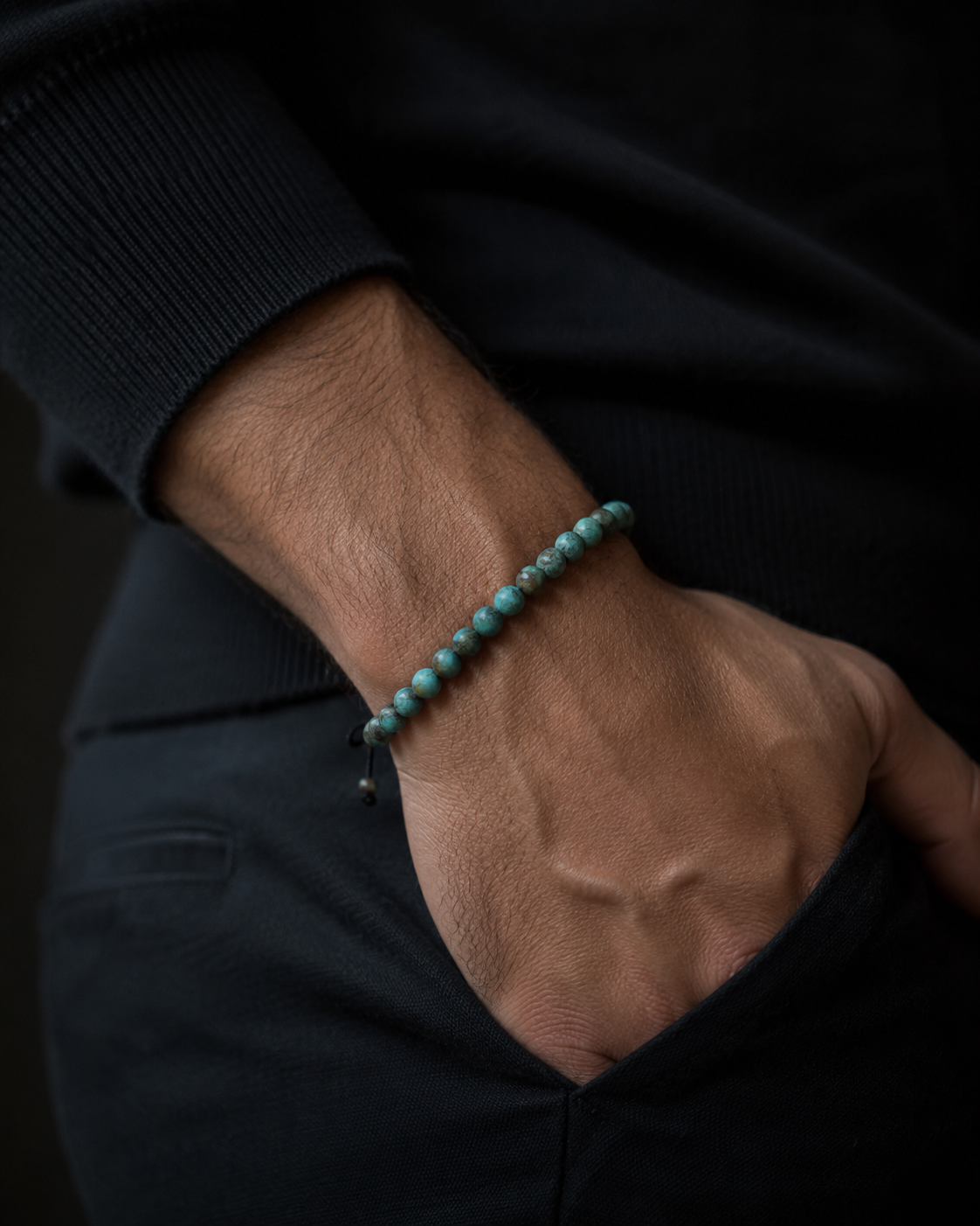 SON Herrenarmband aus 6 mm African-Turquoise-Perlen, markant getragen zu dunklem Strick im maskulinen Premium-Look