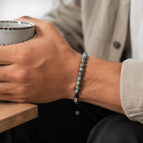 SON Herrenarmband aus 6 mm African-Turquoise-Perlen, alltagstauglich getragen mit beigem Hemd und Keramiktasse