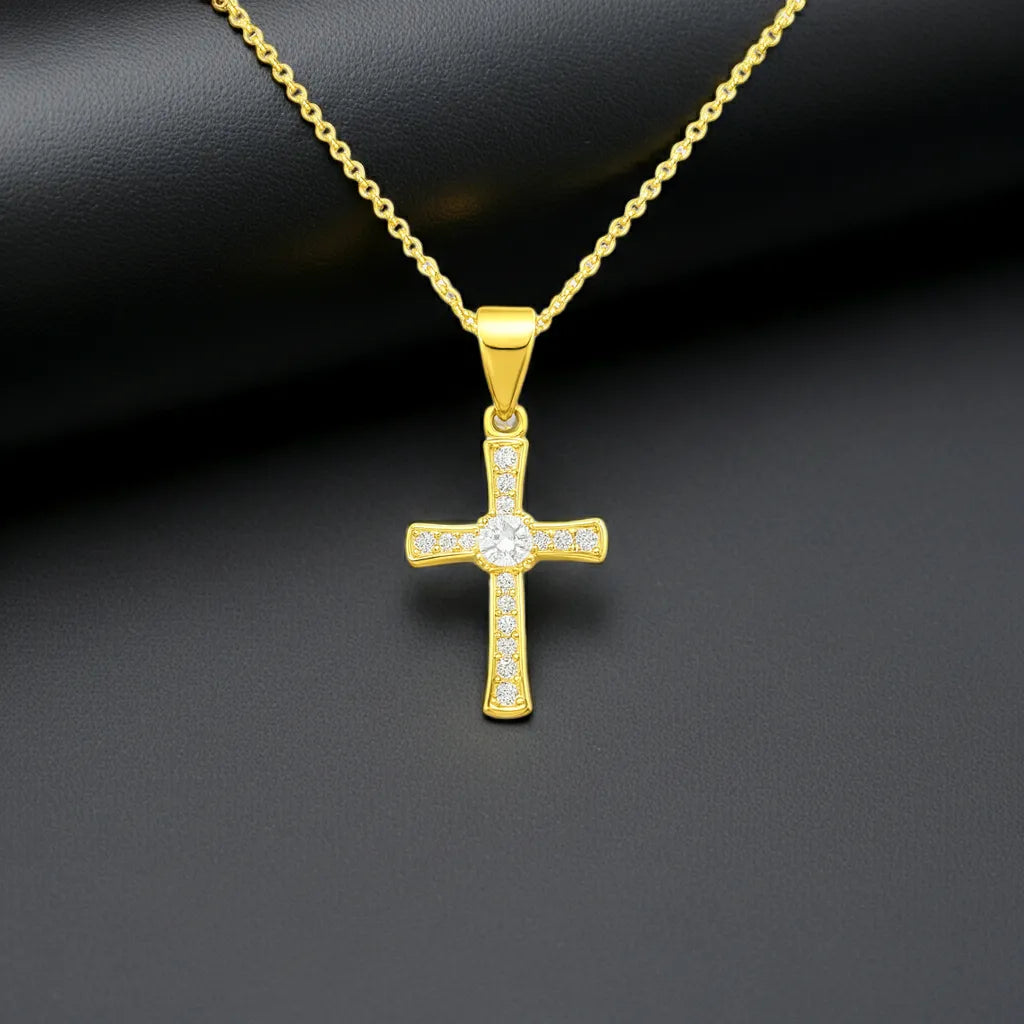Goldene Halskette mit funkelndem Kreuzanhänger, besetzt mit klaren Zirkonia-Steinen auf dunklem Hintergrund – elegantes, modernes Schmuckdesign aus 925 Sterling Silber.
