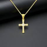 Goldene Halskette mit funkelndem Kreuzanhänger, besetzt mit klaren Zirkonia-Steinen auf dunklem Hintergrund – elegantes, modernes Schmuckdesign aus 925 Sterling Silber.

