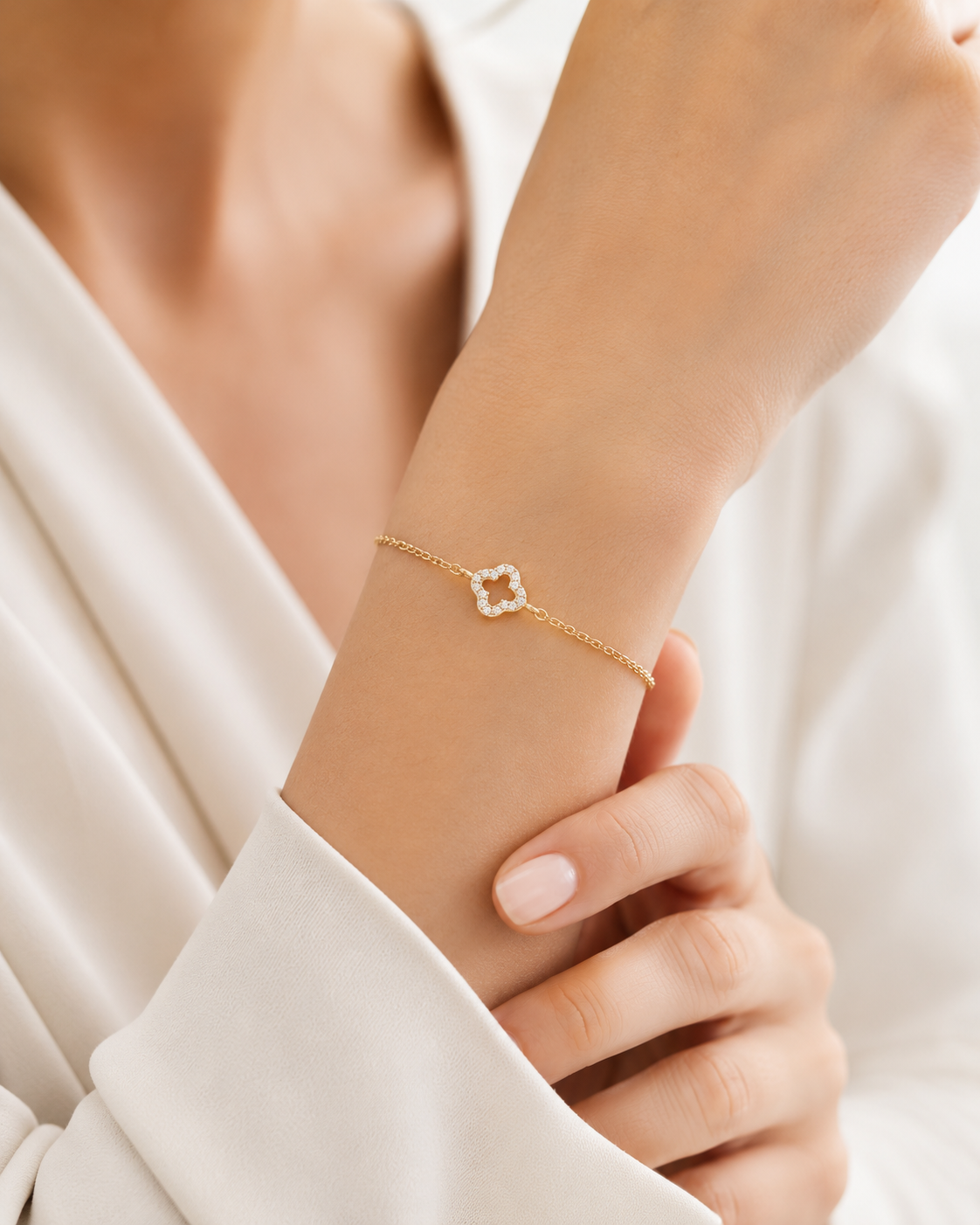 PamelaNor Armband aus vergoldetem 925 Silber mit funkelndem Kleeblatt-Motiv, elegant am Handgelenk getragen.