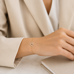 PamelaNor Armband aus vergoldetem 925 Silber mit funkelndem Anhänger, stilvoll zu hellem Blazer und Notizbuch getragen.