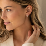 Zarter Seestern-Ohrstecker aus 925 Sterling Silber mit Perlenanhänger, getragen im femininen Lifestyle-Look mit hellem Strick.