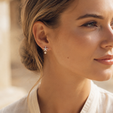 Funkelnder Seestern-Ohrstecker aus 925 Sterling Silber mit kleiner Perle, getragen in warmer natürlicher Lichtstimmung.