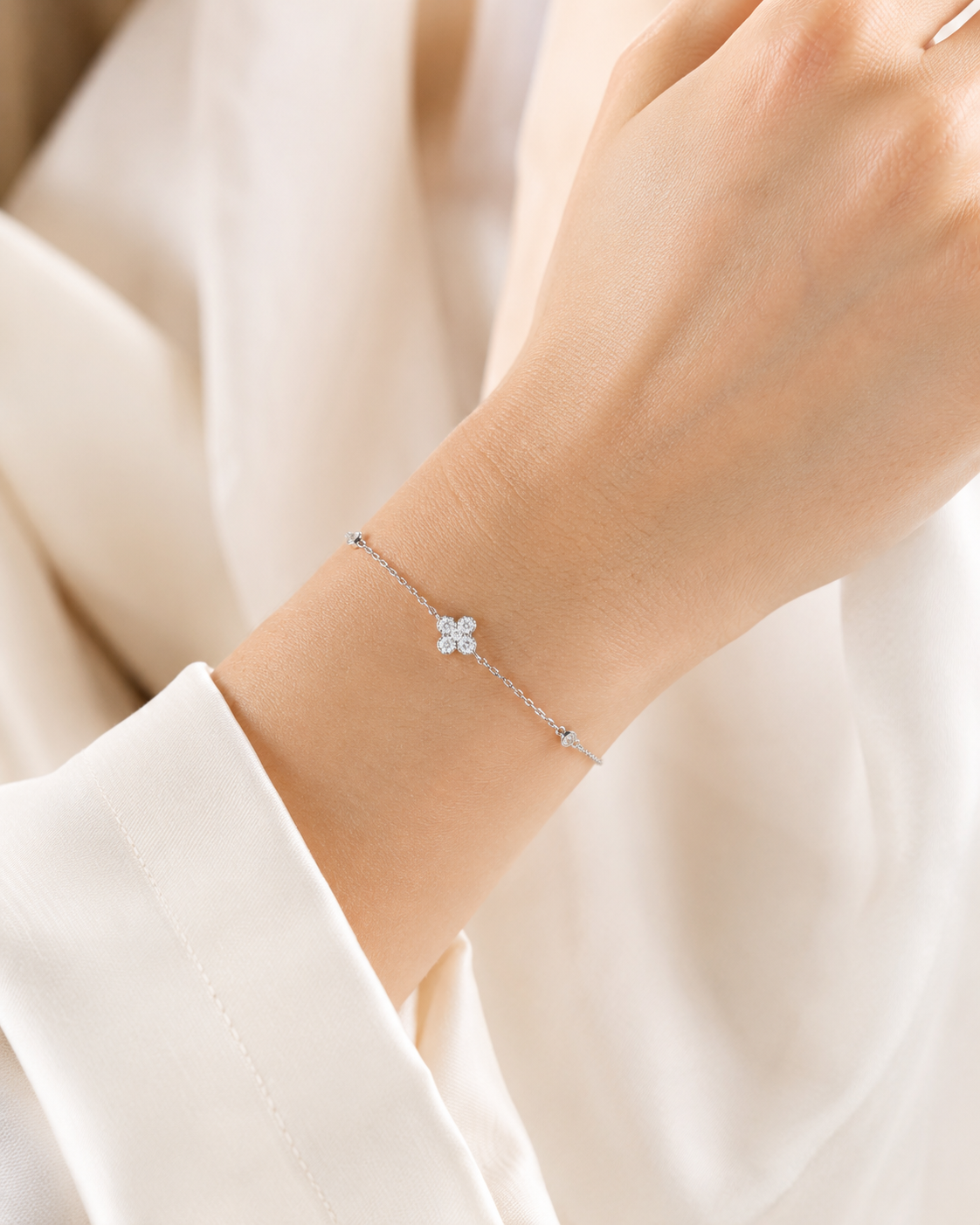 SigneNor Armband aus 925 Sterling Silber mit funkelndem Kleeblatt-Element und Zirkonia am Handgelenk getragen.