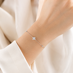 SigneNor Armband aus 925 Sterling Silber mit funkelndem Kleeblatt-Element und Zirkonia am Handgelenk getragen.
