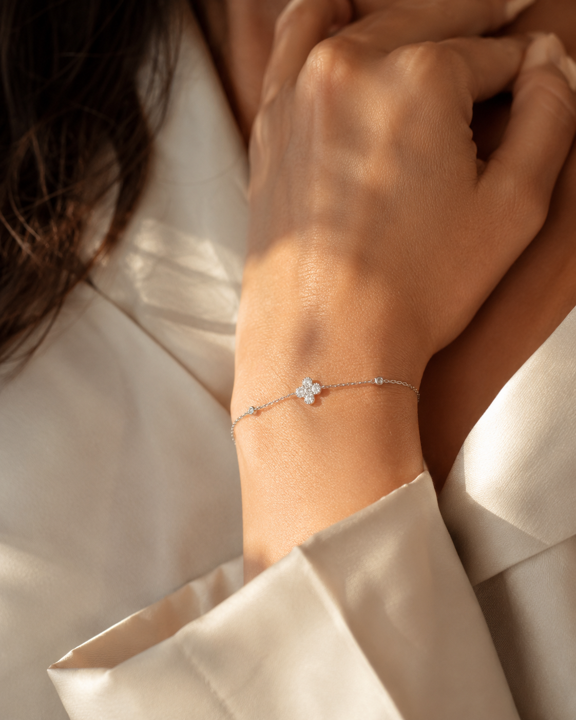 SigneNor Armband aus 925 Sterling Silber mit Zirkonia-Kleeblatt in warmer natürlicher Lichtstimmung am Handgelenk.