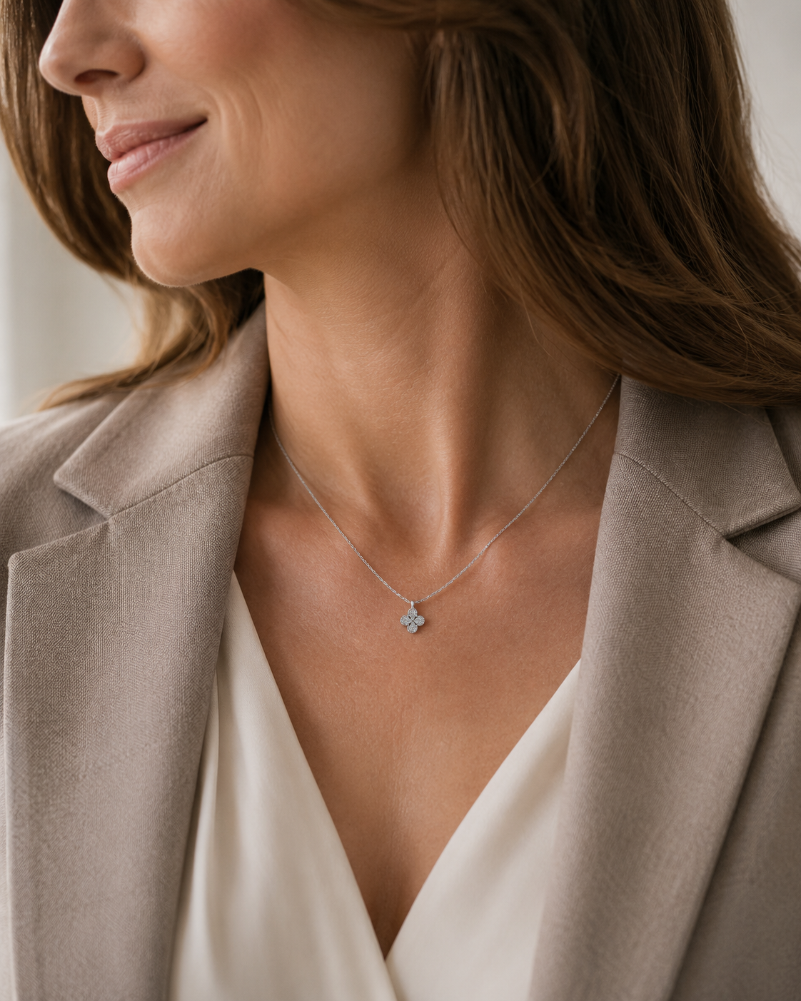 SigneNor Elegante Damenhalskette aus 925 Silber mit Kleeblatt-Anhänger zu hellem Blazer und cremefarbener Bluse.