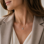 SigneNor Elegante Damenhalskette aus 925 Silber mit Kleeblatt-Anhänger zu hellem Blazer und cremefarbener Bluse.