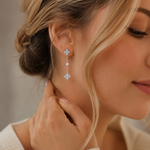 SigneNor Eleganter Ohrhänger aus 925 Sterling Silber mit zarten Kleeblatt-Details, getragen im femininen Lifestyle-Look mit hellem Strick.