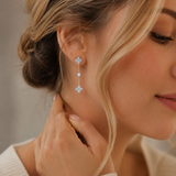 SigneNor Eleganter Ohrhänger aus 925 Sterling Silber mit zarten Kleeblatt-Details, getragen im femininen Lifestyle-Look mit hellem Strick.