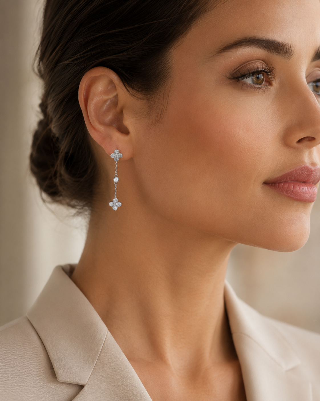 SigneNor Funkelnder Ohrhänger aus 925 Sterling Silber mit Kleeblatt-Motiven, kombiniert mit hellem Blazer im modernen Editorial-Look.